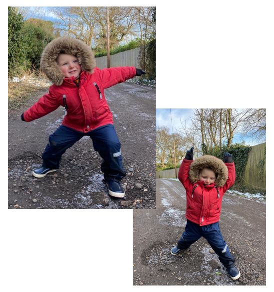 Child in red jacket stretching arms to the side and upwards