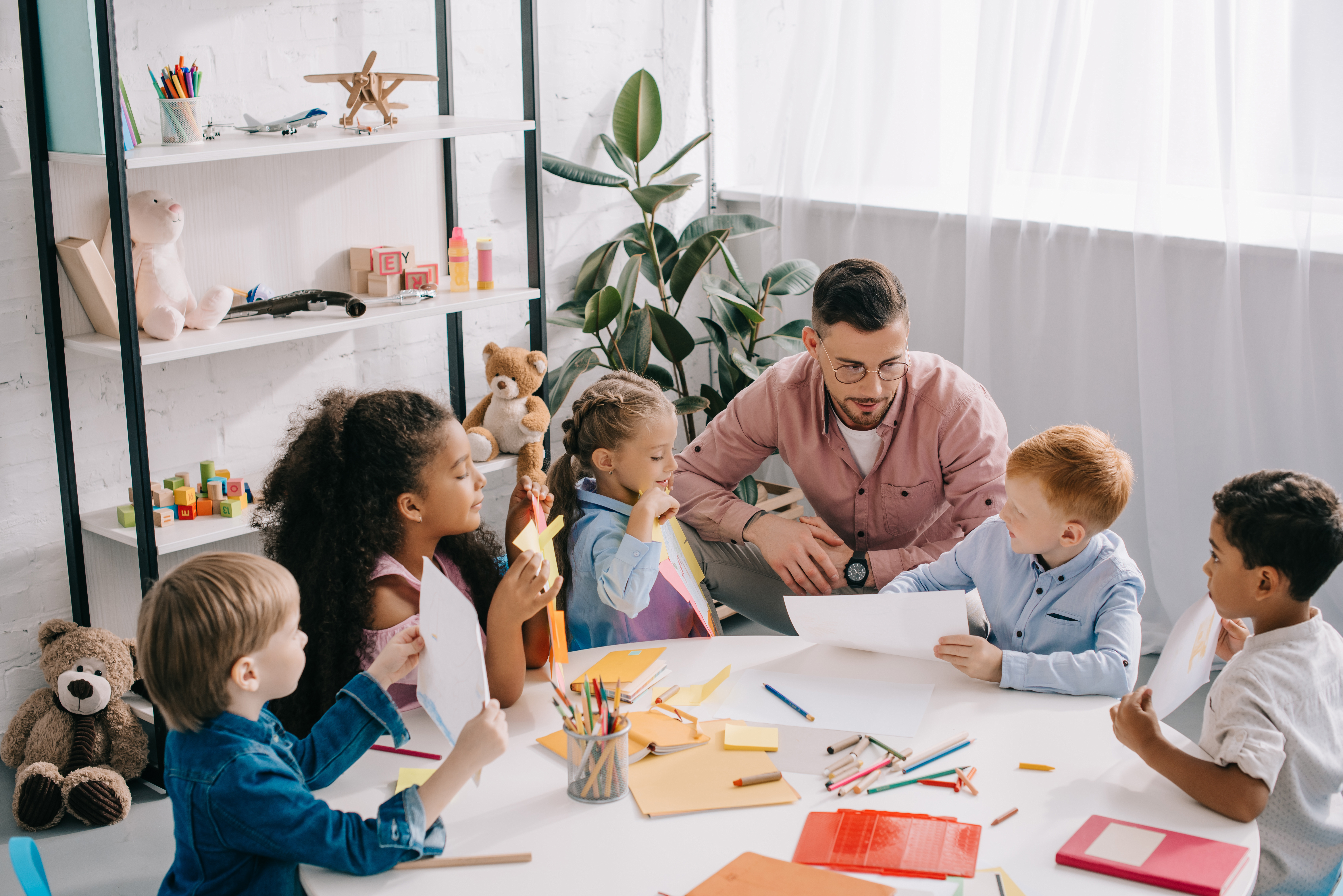 Adult with Early Years children round white circle table