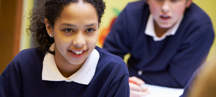 School girl with pencil at desk