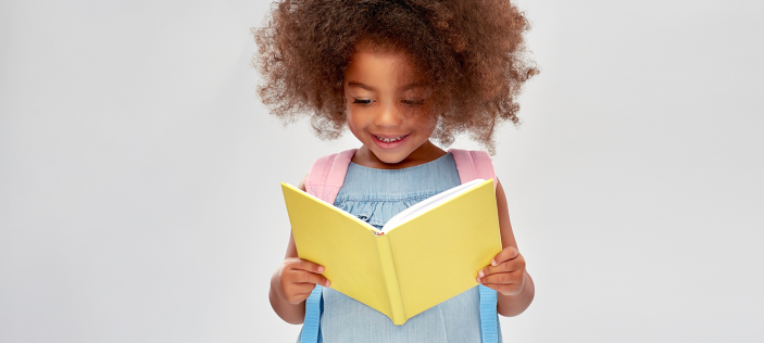 Girl reading yellow book on white background