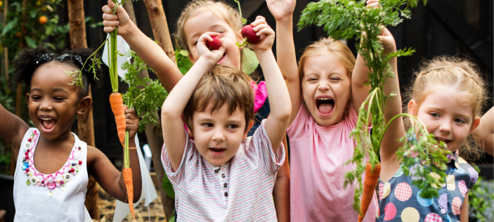 Happy Early Years children brandishing plants 