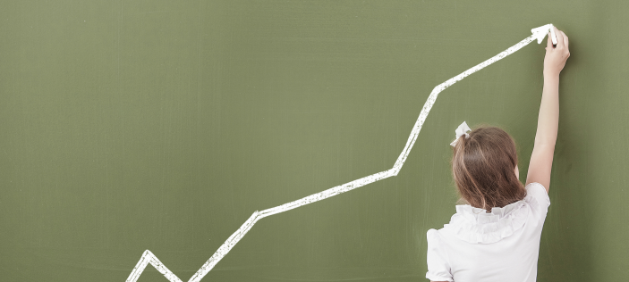 Girl drawing arrow on chalk board