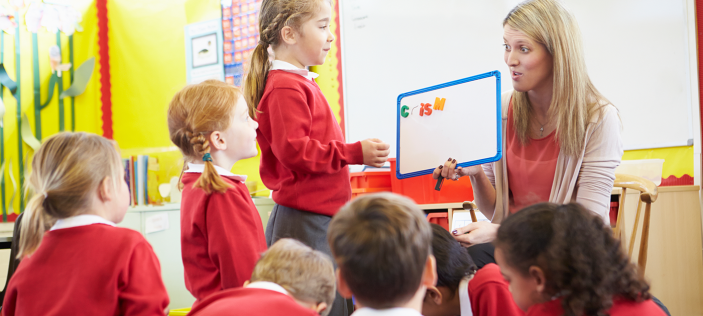 Primary children in red jumpers in classroom