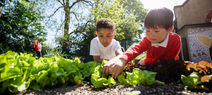 Children playing outside with vegetables 
