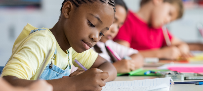 Girl writing in book with pencil