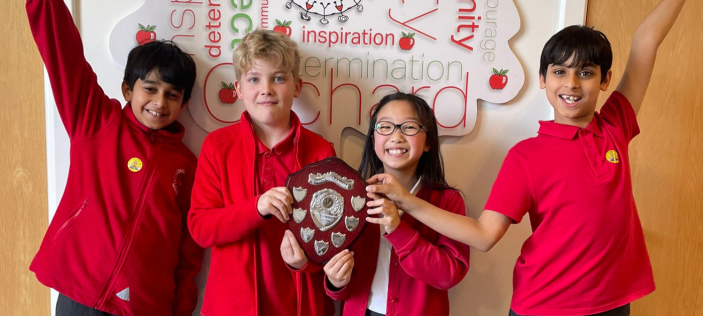 Happy children holding a trophy together