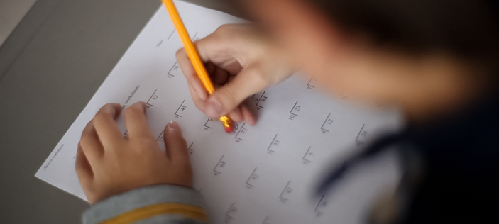 Erasing maths equation with a yellow rubber tipped pencil