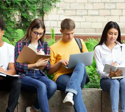 group of young people sitting on a wall