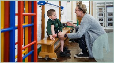 boy and teacher talking in a gym