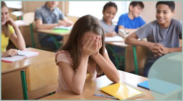 girl with head in hands in a classroom