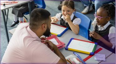 male teacher with 2 primary pupils