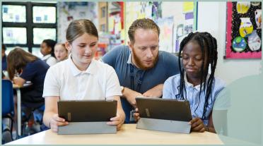 male teacher with 2 pupils on ipads