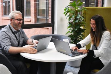 hfl education staff - man and woman looking at their laptops