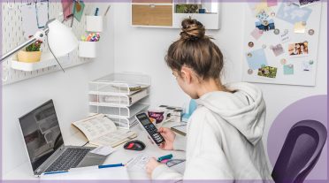 secondary age girl using laptop at home