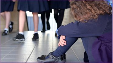 girl sitting on the floor in school uniform