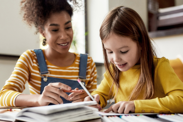 woman teaching child at home