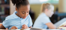 School girl reading from book