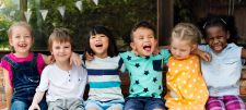 Keeping up appearances: encouraging attendance at non-statutory school age Happy Early Years children sat together with arms round eachother