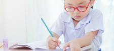 All change! Moving on from statutory Key Stage 1 assessment Child with red glasses writing in book
