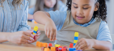 The Concrete, Pictorial Abstract (CPA) approach for teaching and mastering times tables Girl with counting blocks