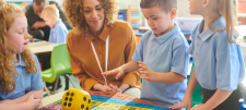 The ‘I do’ in maths: giving careful thought to the initial teaching model children with teacher and dice