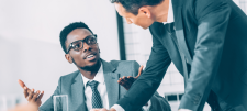 Let’s embrace the discomfort: navigating challenging conversations People in suits talking with eachother